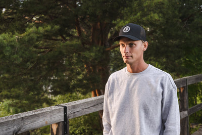 Man in a black 5-panel Retro Trucker cap