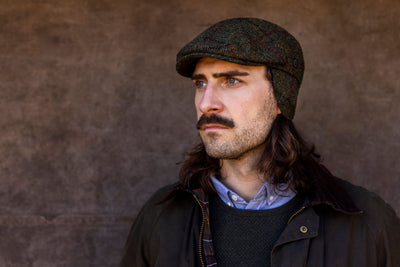 Man med tweed keps med öronlappar